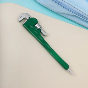 Detailed close-up of a green pipe wrench-shaped ballpoint pen with a silver writing tip
