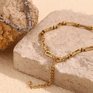 Detailed view of gold and silver paperclip chain links with lobster clasp on stones