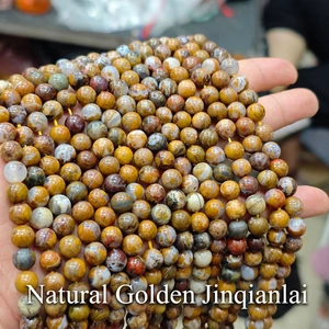 Detailed close-up of natural Jinqianlai stone beads with unique brown and yellow textures