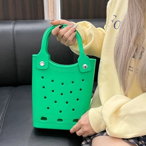 Detail of green EVA beach tote bag featuring a perforated hollow design and top handles