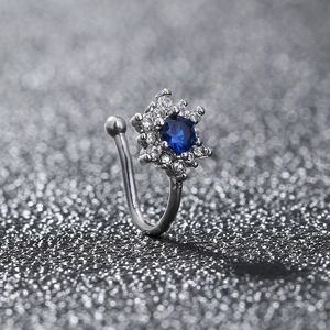 Macro shot of silver non-piercing clip jewelry with blue gemstone and clear zircon stars