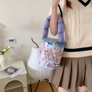 Close-up of a blue winter scene canvas bucket bag with purple puffy padded handle