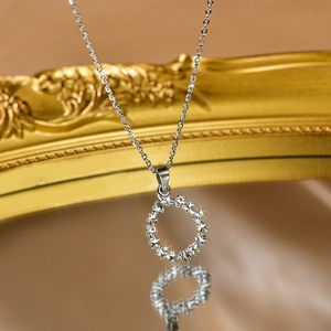 Close-up of silver star pendant necklace with zircon stones on reflective surface
