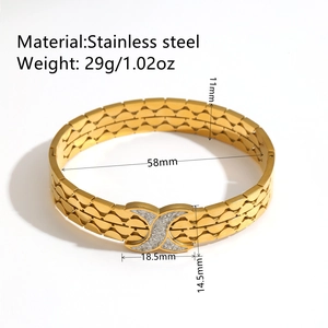 Bracelet jonc doré en acier inoxydable avec lunes et cristaux sur un fond blanc pur