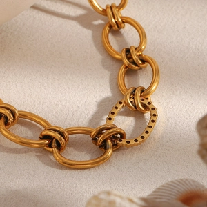 Close-up of 18K gold plated chain necklace featuring a dark zircon stone inlay link