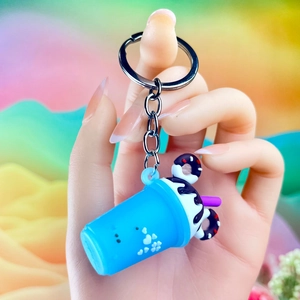 Close-up of creative ice cream keychain with blue milk tea cup and chocolate donut detail
