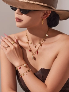 Détail du coffret bijoux doré avec pendentifs coccinelle, piment et trèfle à quatre feuilles