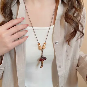 Vintage red resin mushroom pendant necklace with wooden beads on linen shirt