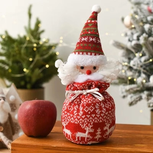 Detail of Christmas Santa knit candy bag with drawstring and reindeer pattern on wooden desk