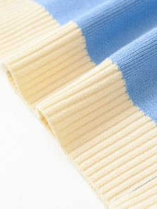 Detail of light blue and creamy white knitted fabric with refined ribbed cuffs and textures