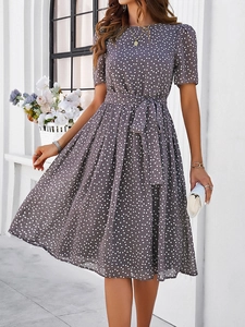 Détail d'une robe grise à pois avec nœud à la taille et ourlet évasé en ligne A