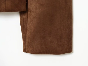 Gros plan détaillé de la texture en daim marron et des coutures sur la manche du blazer