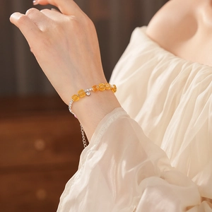 Detail of yellow crystal beaded bracelet with silver chain on female wrist