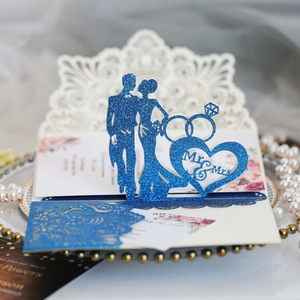 Intricate laser-cut blue glitter wedding invitation card with 3D Mr & Mrs pop-up design