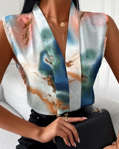 Detail of elegant deep V-neckline and colorful abstract print on a satin sleeveless top