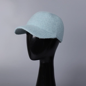 Détail d'une casquette de baseball en tricot bleu clair montrant la texture douce sur modèle