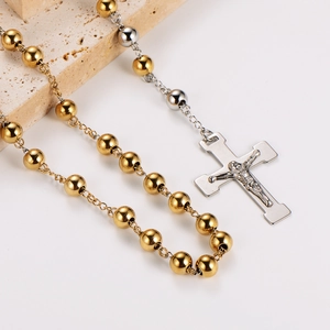 Detail of gold and silver beaded necklaces with crucifix pendants on stone display