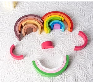Detailed top view of rainbow wooden blocks arranged as a face on a soft knitted blanket