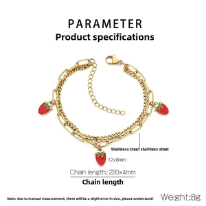 Detail of double-layer gold stainless steel bracelet with cute red strawberry charms