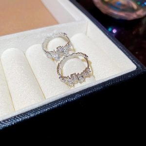 Macro shot of silver geometric hoop earrings with zircon stones on white velvet
