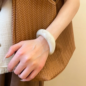 Detailed view of translucent resin bangle with a polished finish on a female wrist