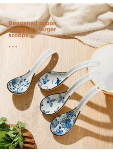 Detail of four ceramic soup spoons with traditional blue floral patterns on wooden table