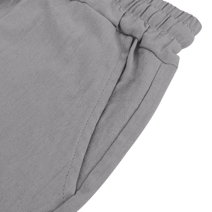 Detail of light gray linen shorts featuring an elastic waistband and side pockets