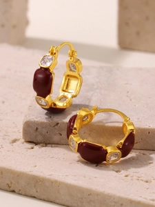 Macro shot of 18k gold plated hoop earrings with red enamel and white zircon inlay
