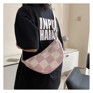 Detail of checkered crescent bag with purple woven texture and wide canvas strap