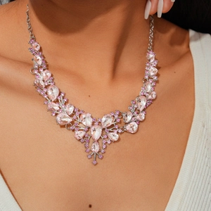 Detailed view of silver necklace with pink waterdrop crystals on a model's neck