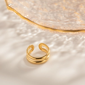 Macro shot of 18k gold plated double layer open ring on textured glass background