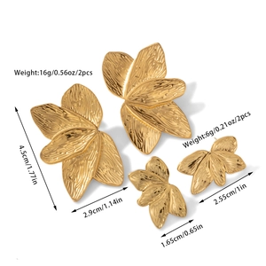 Macro detail of gold-plated leaf earrings with textured surface and size specifications