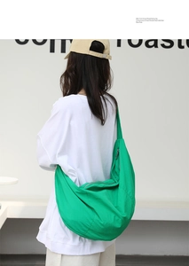 Dettaglio della borsa a mezzaluna in nylon verde con grande capacità e design minimalista