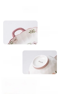 Detail of pink ceramic bowl showing dual handles, non-slip base and hand-painted rim