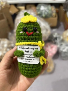 Detail of handmade crochet green vegetable doll with an emotional support message card