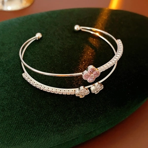 Macro detail of silver double-layer bangle with pink and white clover-shaped zircons