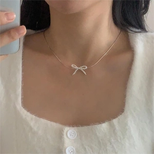 Detail view of 925 silver pearl bow necklace on model's neck for elegant daily wear