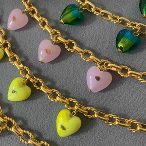 Detail of colorful Murano glass heart pendants on gold plated chunky link chains