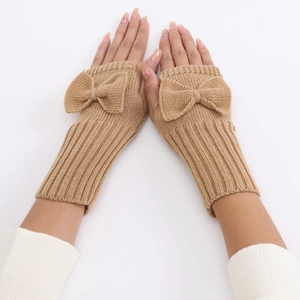 Detail of camel knitted fingerless gloves with bow decoration and ribbed texture