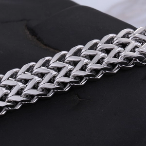 Macro shot of silver polished heavy metal chain on dark stone texture background