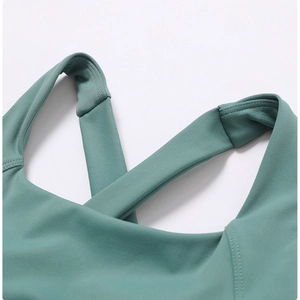 Dettaglio delle spalline incrociate e cuciture fini su un reggiseno sportivo verde salvia