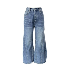 Detail of high waisted wide leg jeans featuring vintage wash cat-scratch whiskers and stitching