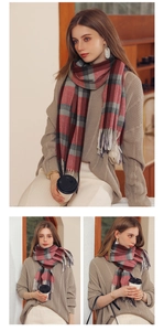 Close-up of soft red and grey plaid cashmere-like scarf featuring decorative tassels