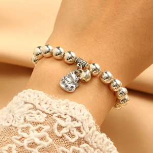 Detailed close-up of a silver beaded bracelet with Maneki Neko charm and bell