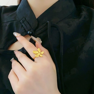 Detailed view of a gold flower ring in titanium steel on a model's hand
