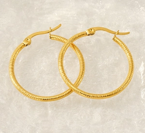 Detail showing the textured horizontal grooves on 18k gold-plated hoop earrings