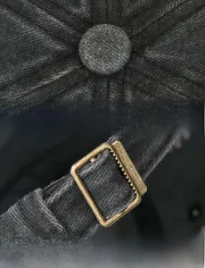 Detail of dark grey vintage cap showing top button stitching and metal back strap buckle