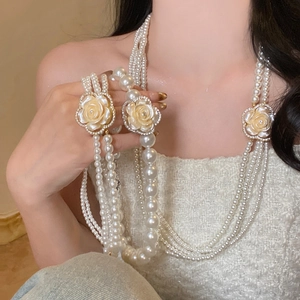 French vintage multi-layer pearl necklace with white camellia flower on a female model