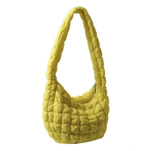 Bright yellow quilted cloud bag with puffy texture and shoulder strap on white background