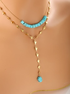 Detailed close-up of double-layered gold heart chain necklace with turquoise pendant